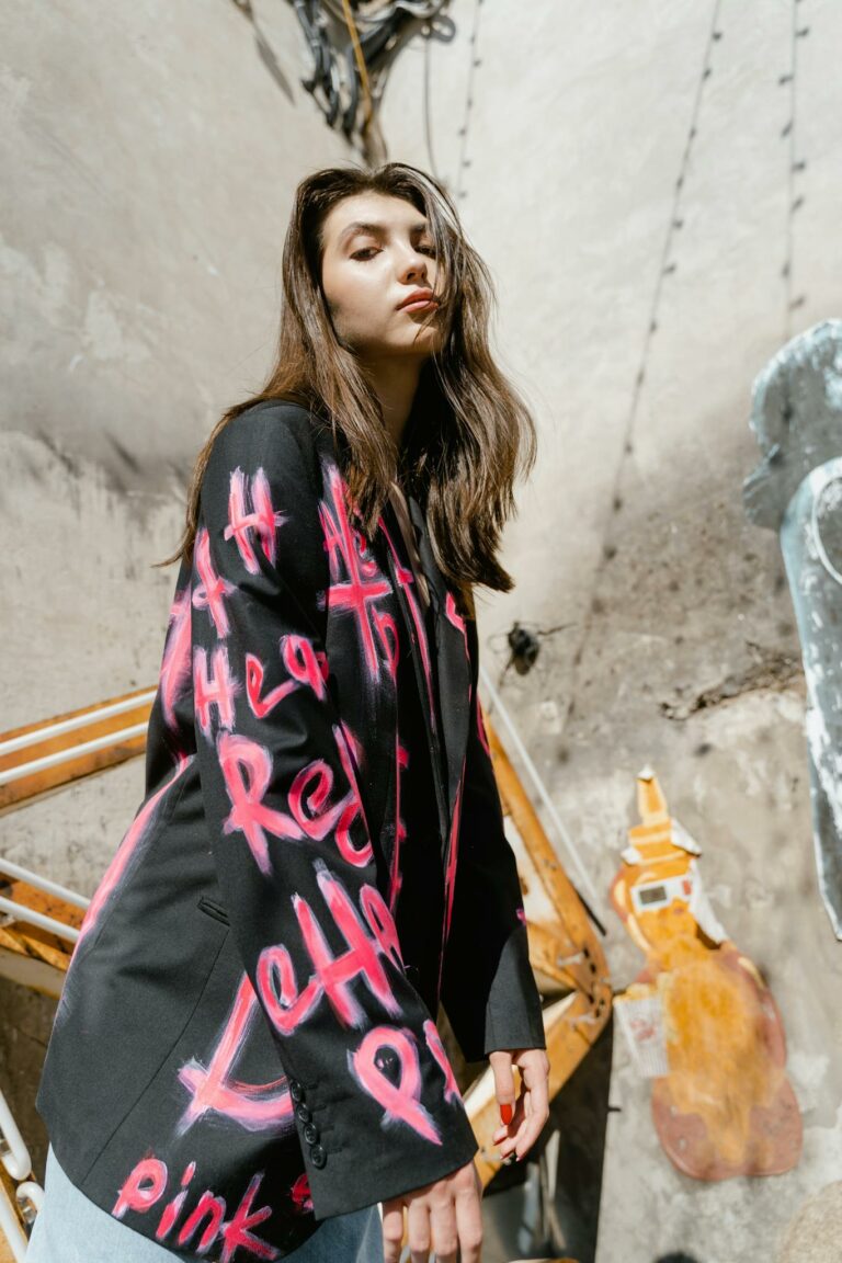 Fashionable woman wearing a graffiti-designed blazer outdoors in urban style.